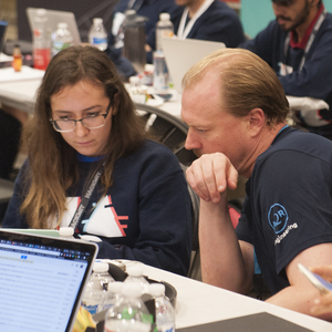 A HackMIT mentor working with a hacker on solving a technical issue