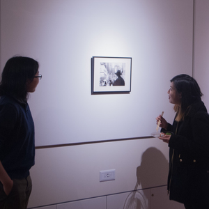Ivy Li '20, explains her photos to a curious member of audience in her black-and-white photo exhibition in the Wiesner student gallery Dec. 8. Her photos will be exhibited in the gallery for the next month
