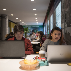 Two students work on their laptops in 26-110, the Compton Lounge, which houses a well-lit individual study space, snacks, and drinks